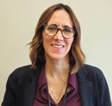 A person wearing glasses and a black jacketDescription automatically generated